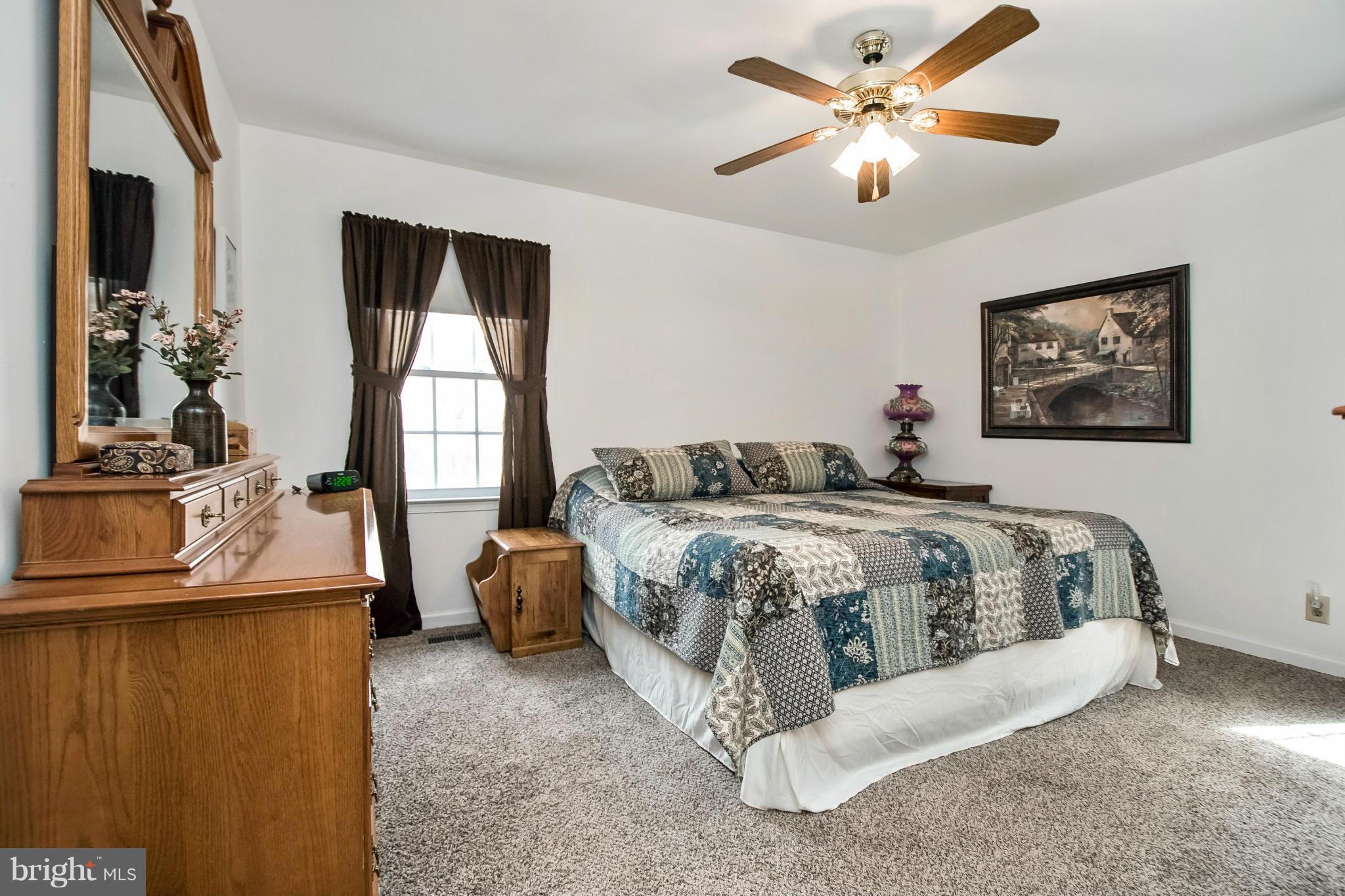 6101 Ridge Tree Road Fredericksburg, VA 22407 - Photo 18 of 30 a bedroom with a bed and a chandelier
