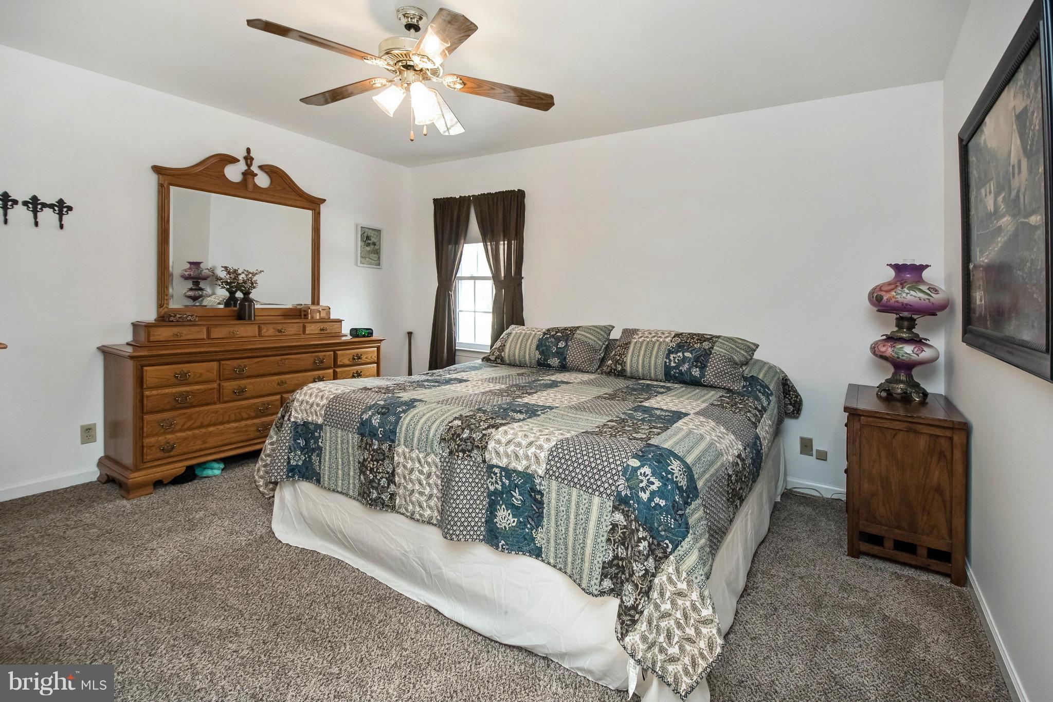 6101 Ridge Tree Road Fredericksburg, VA 22407 - Photo 19 of 30 a bedroom with a bed and a chandelier
