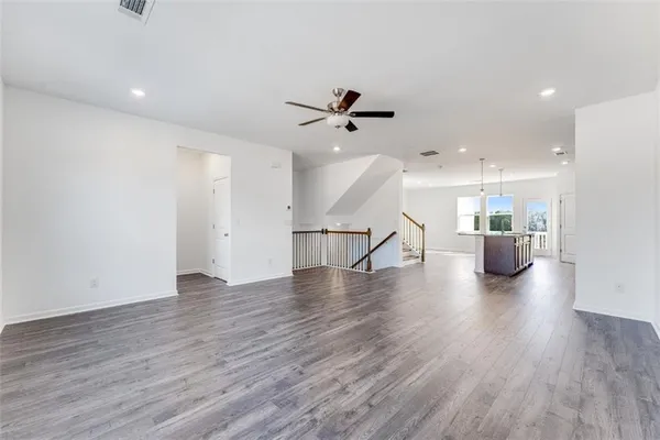 a view of kitchen with kitchen island a sink wooden floor and stainless steel appliances