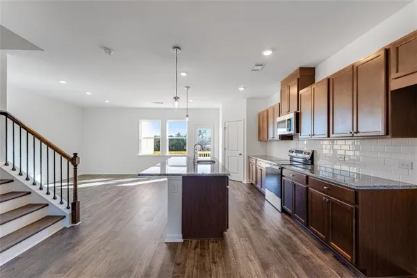 a kitchen with stainless steel appliances granite countertop a stove and a sink