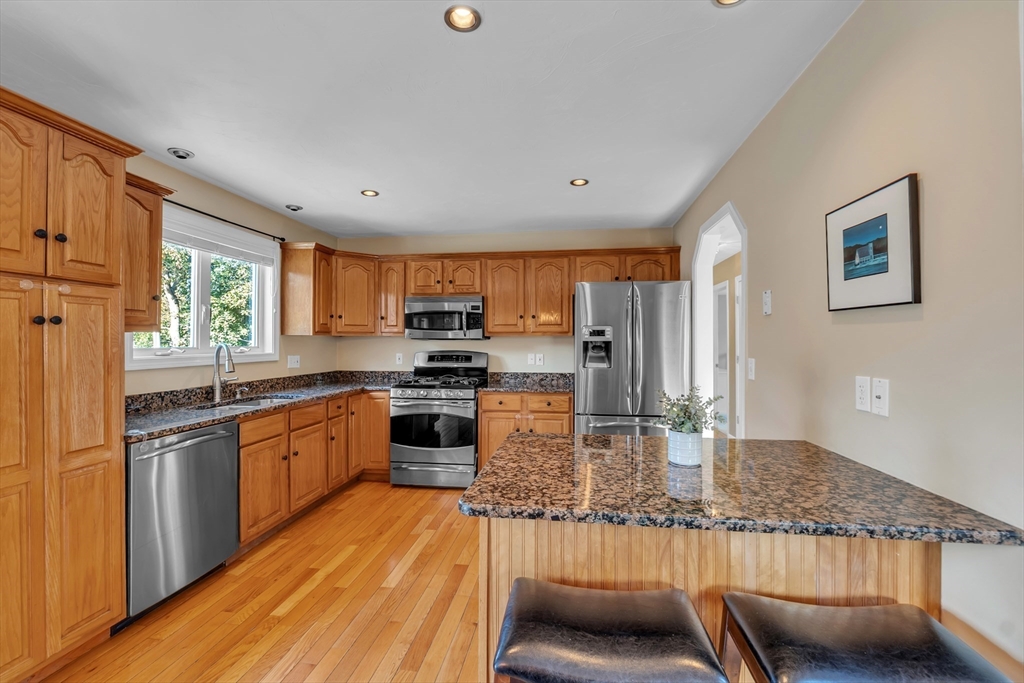 133 Derby Street Worcester, MA 01604 - Photo 4 of 42 a kitchen with stainless steel appliances granite countertop a refrigerator a stove top oven a sink dishwasher and couches with wooden floor