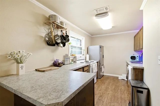 a kitchen with a sink a stove and a wooden floors