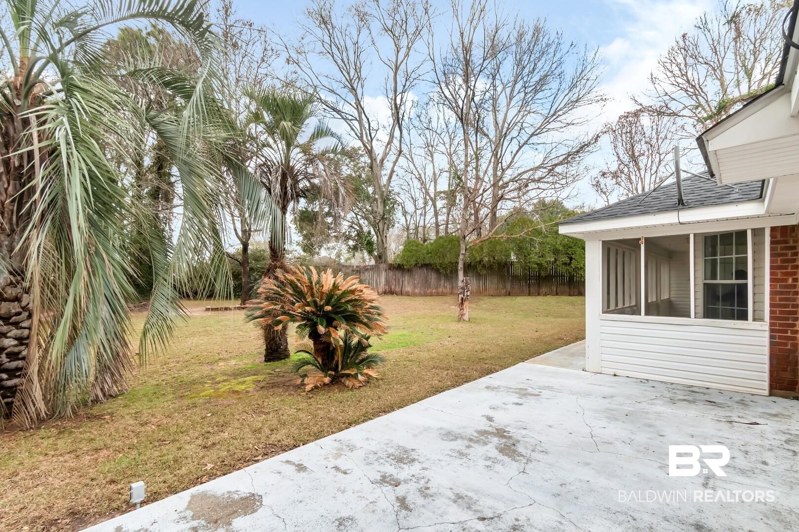 10006 Wedgefield Court Mobile, AL 36608 - Photo 3 of 34 View of yard featuring a sunroom, a patio, and fence