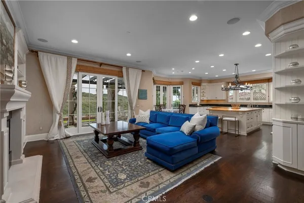 a living room with furniture and a view of kitchen