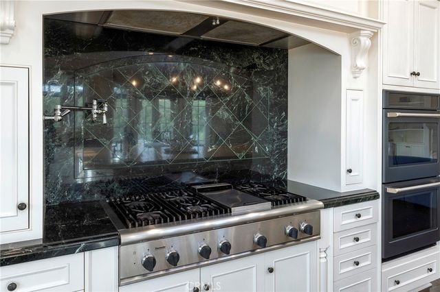 a kitchen with granite countertop a stove and a sink