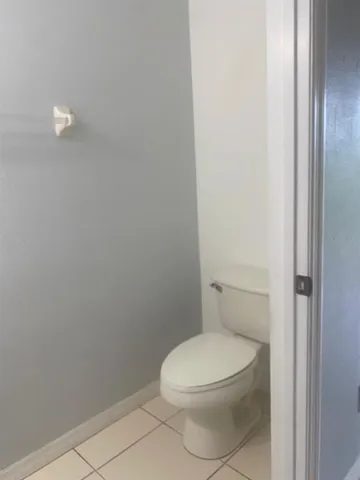 a white toilet sitting next to a white cabinet