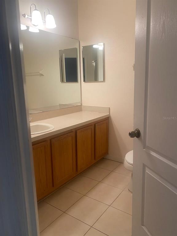 9323 Flowering Cottonwood Road Orlando, FL 32832 - Photo 16 of 23 a bathroom with a sink a toilet and mirror