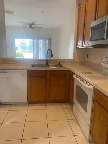 a kitchen with a sink a stove top oven a counter space and cabinets