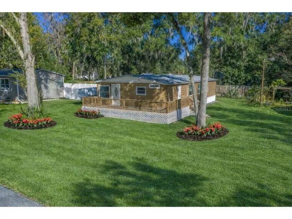 a front view of a house with a garden and trees