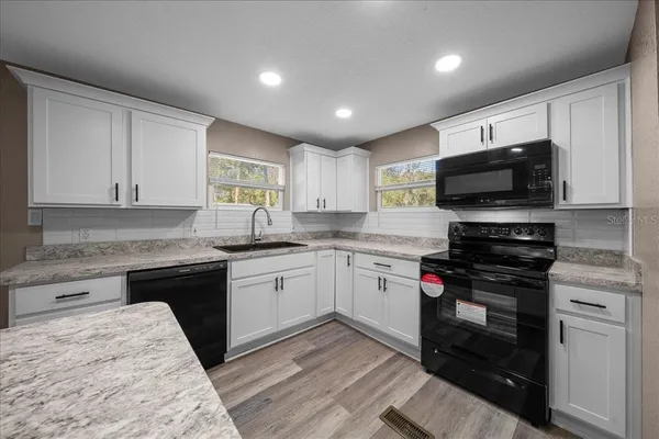 a kitchen with a sink stove and microwave
