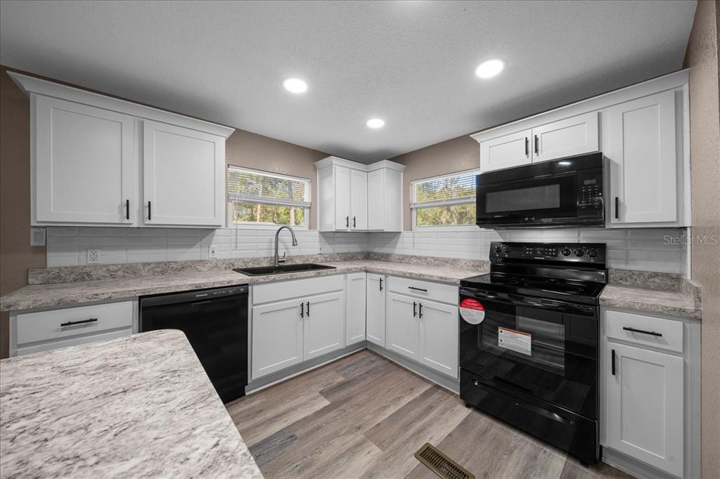 339 Southwest 83rd Street Ocala, FL 34476 - Photo 12 of 34 a kitchen with a sink stove and microwave