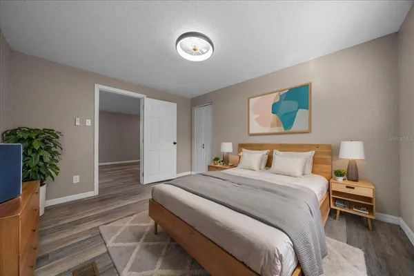 a bedroom with a large bed and a potted plant