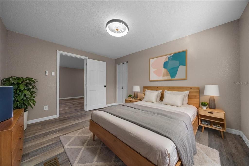 339 Southwest 83rd Street Ocala, FL 34476 - Photo 21 of 34 a bedroom with a large bed and a potted plant