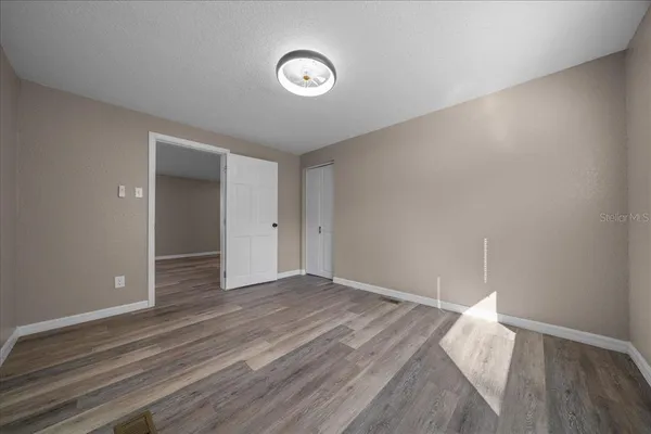 a view of empty room with wooden floor