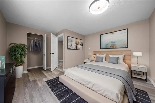 a bedroom with a large bed and a potted plant