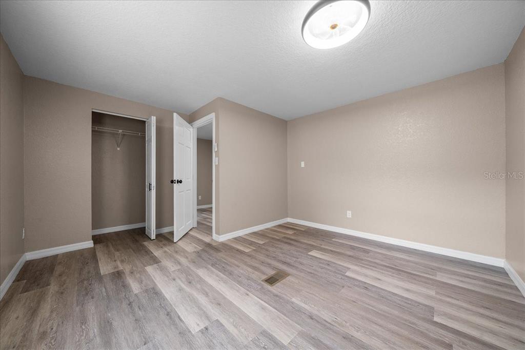 339 Southwest 83rd Street Ocala, FL 34476 - Photo 24 of 34 an empty room with wooden floor and mirror