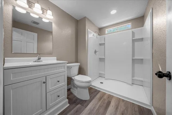 a bathroom with a sink a toilet and shower