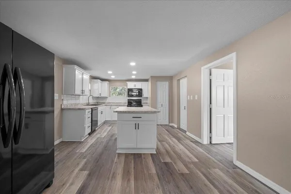 a kitchen with white cabinets and stainless steel appliances
