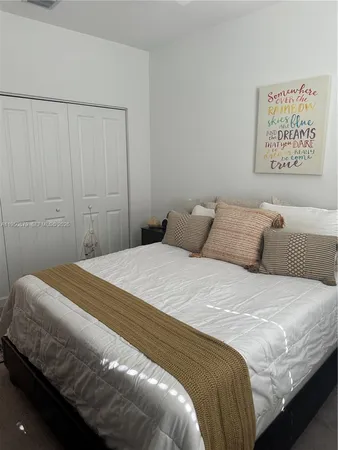 a bedroom with a bed and a white wall