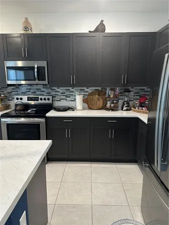 a kitchen with a sink a stove top oven and cabinets