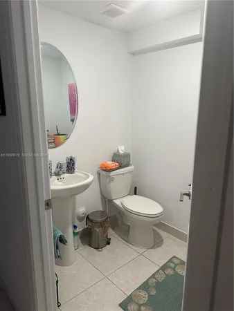 a white toilet sitting next to a bathroom sink
