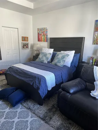 a bedroom with a bed lamp and a couch