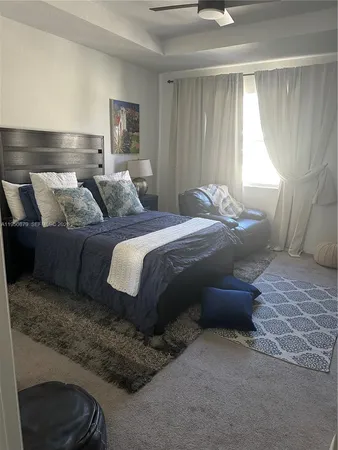 a large bed sitting in a bedroom next to a window and a larger closet
