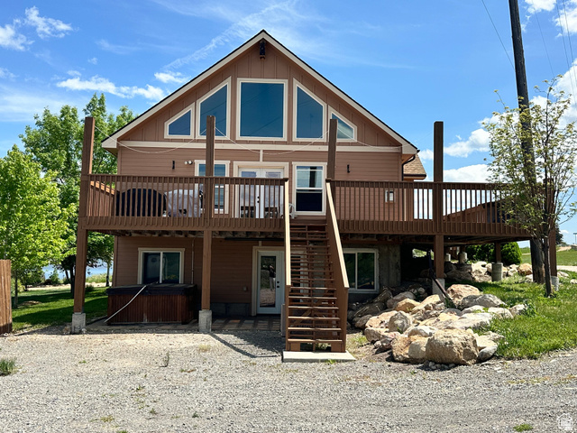 12 Crook Street Fish Haven, ID 83287 - Photo 1 of 35 Back of house featuring a wooden deck, a hot tub, board and batten siding, and a patio