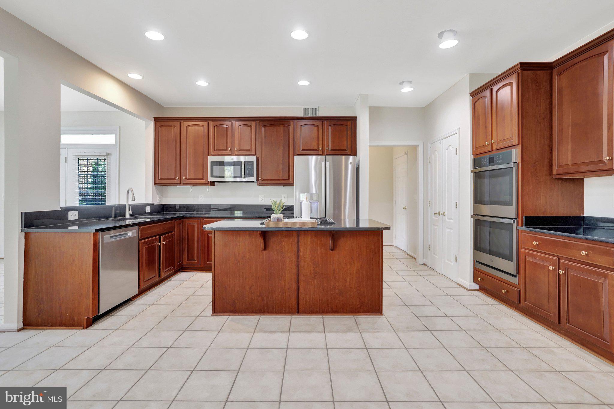 6247 Rolling Spring Court Springfield, VA 22152 - Photo 18 of 52 a kitchen with stainless steel appliances granite countertop a stove a sink and a refrigerator