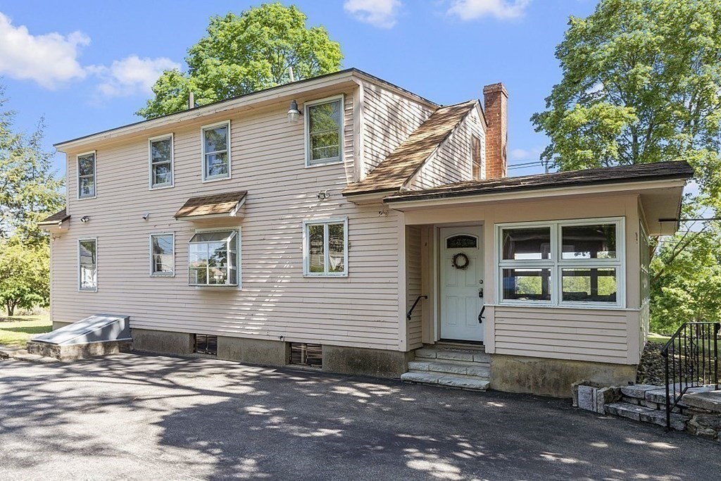 338 Donohue Road Dracut, MA 01826 - Photo 5 of 38 a view of a house with a yard and lawn chairs under an umbrella