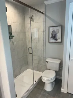 a bathroom with a toilet and a shower
