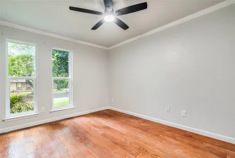 an empty room with a window and wooden floor