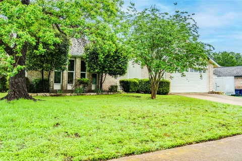 a view of a house with a yard and tree