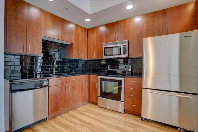a kitchen with stainless steel appliances a refrigerator sink and microwave