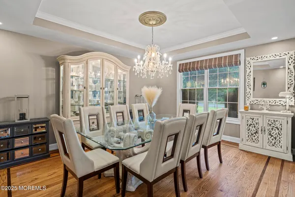 a dining room with furniture a chandelier and wooden floor