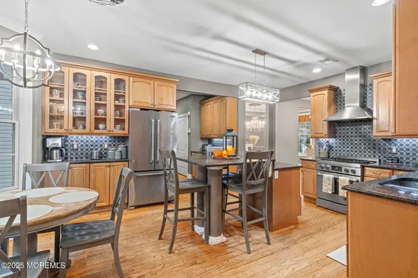 a kitchen with stainless steel appliances wooden floor dining table and chairs