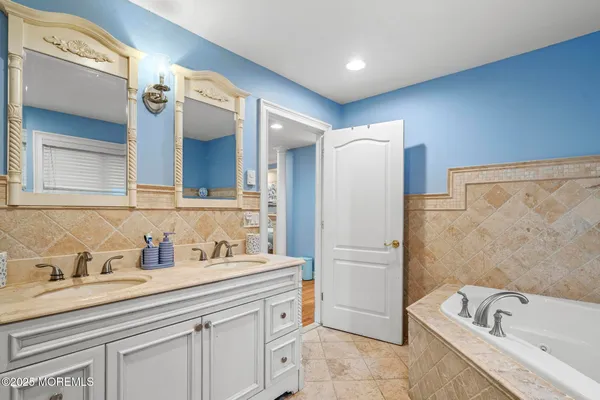 a bathroom with a tub sink and mirror