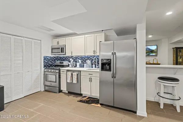 a kitchen with white cabinets and stainless steel appliances