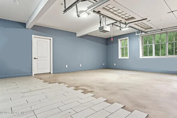 an empty room with windows and ceiling fan