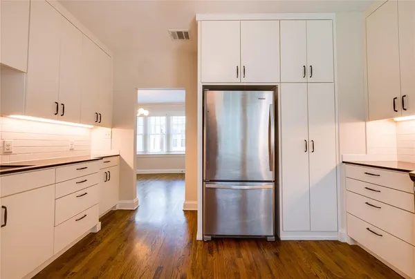 a kitchen with wooden floors and white appliances