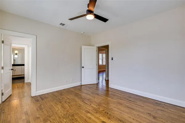 wooden floor in an empty room with a bathroom