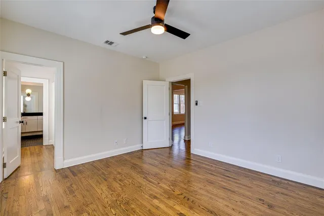 wooden floor in an empty room with a bathroom