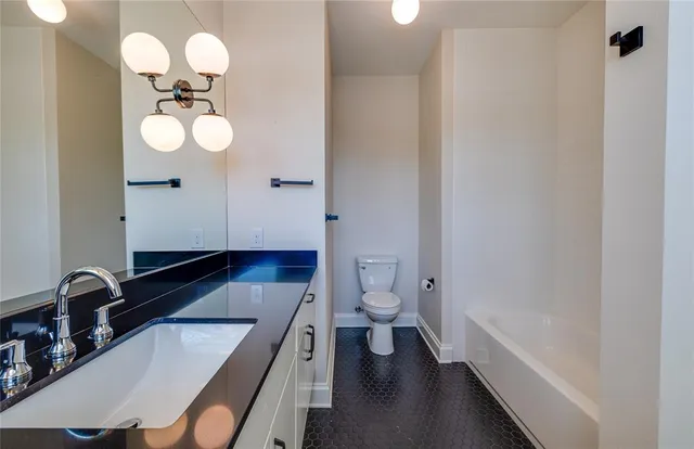 a bathroom with a sink a toilet and bathtub