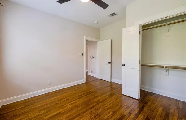 a view of an empty room with wooden floor