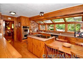 135 Doubleday Road Tryon, NC 28782 - Photo 5 of 12 a kitchen with stainless steel appliances kitchen island wooden cabinets and a large window