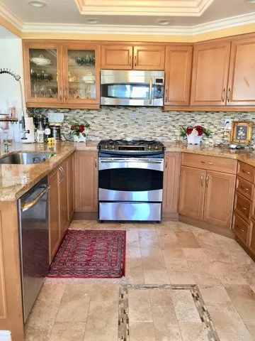 a kitchen with stainless steel appliances granite countertop a stove a sink and a microwave