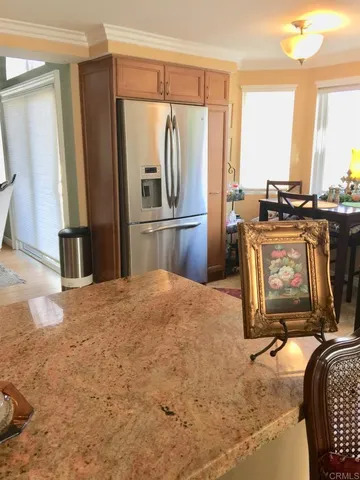 a kitchen with kitchen island granite countertop a refrigerator stove and sink