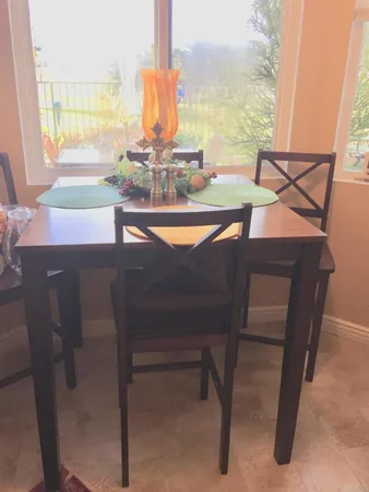 a dining table with chairs and window