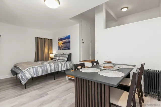 a bedroom with bed a mirror and a table