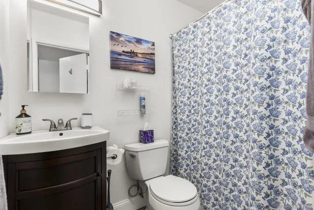 a bathroom with a toilet a sink and a mirror